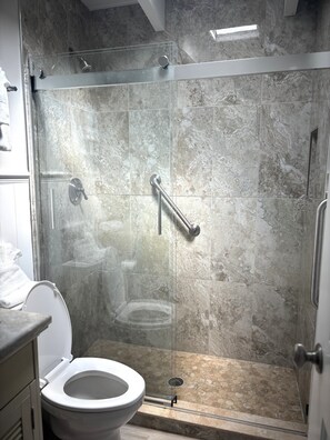 Ein Badezimmer mit Duschkabine, Toilette und Waschbecken.