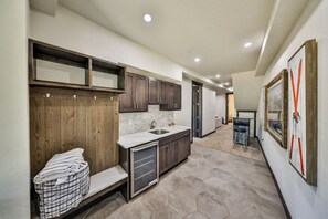 A modern kitchen with dark wooden cabinets, a white countertop, and a built-in dishwasher. - Hot Tub | Mountain Views | Walk To Downtown (Winter Park)
