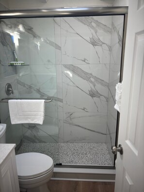 Ein Badezimmer mit Duschkabine, Toilette und Waschbecken.