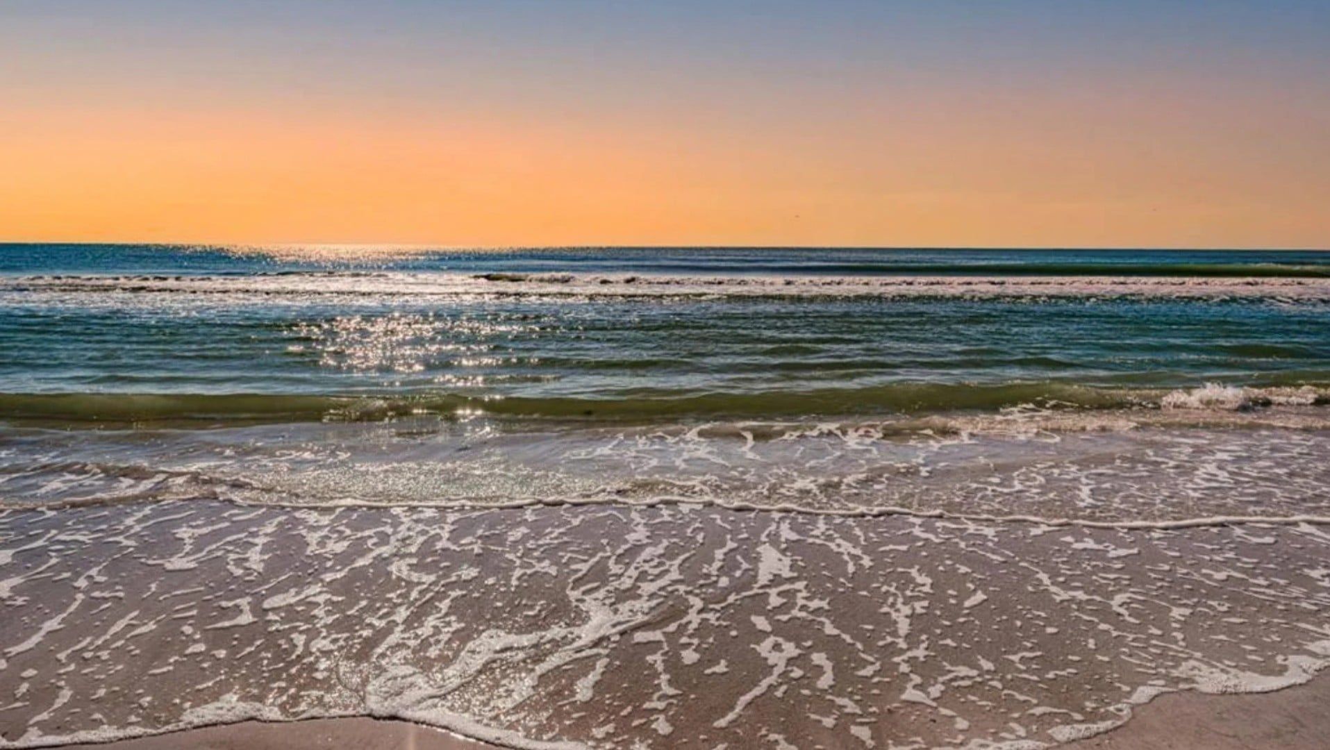 A beach with waves gently lapping onto the shore.