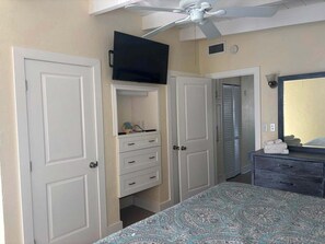 A bedroom with a bed, a dresser, a television, and a ceiling fan. - SR-36 -Cozy 1BR Siesta Key condo with king bed and sleep sofa. (Siesta Key)