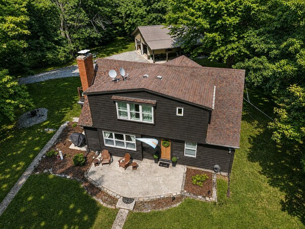 A two-story house with a patio, satellite dishes, and a well-maintained lawn.