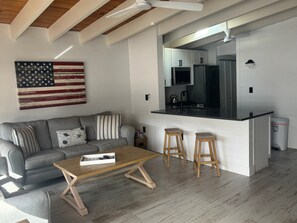 A modern kitchen with white cabinetry, a black countertop, and a stainless steel refrigerator. - SR-45 - 1BR Siesta Key condo with king bed, sleep sofa, and courtyard views. (Siesta Key)