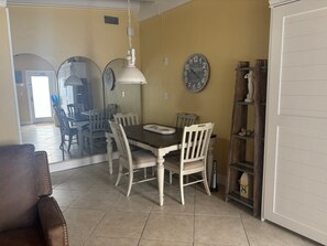 Un comedor con una mesa, sillas y un reloj en la pared.