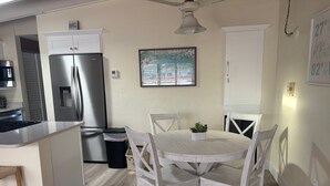 A kitchen with a refrigerator, stove, and dining table with chairs. - 1BR Siesta Key apartment with king bed and sleep sofa for 4. (Siesta Key)