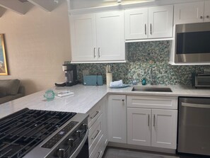 A modern kitchen with white cabinets, a built-in stove, and a microwave. - 1BR Siesta Key apartment with king bed and sleep sofa for 4. (Siesta Key)