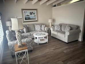 A living room with a sofa set, a coffee table, and a lamp. - Cozy 1BR Siesta Key apartment with courtyard view (Siesta Key)