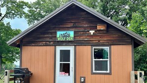 A small wooden cabin with a sign reading 'WOLF DEN'.