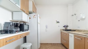 A compact kitchen with a microwave, coffee maker, and refrigerator. There is a small stool and a sink with a faucet. - Apt in Condo w/ BBQ in Capivari Lvr0017 (Campos do Jordão)