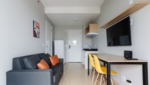 Ein modernes Apartment mit Wohnbereich, Küchenzeile und Essplatz.