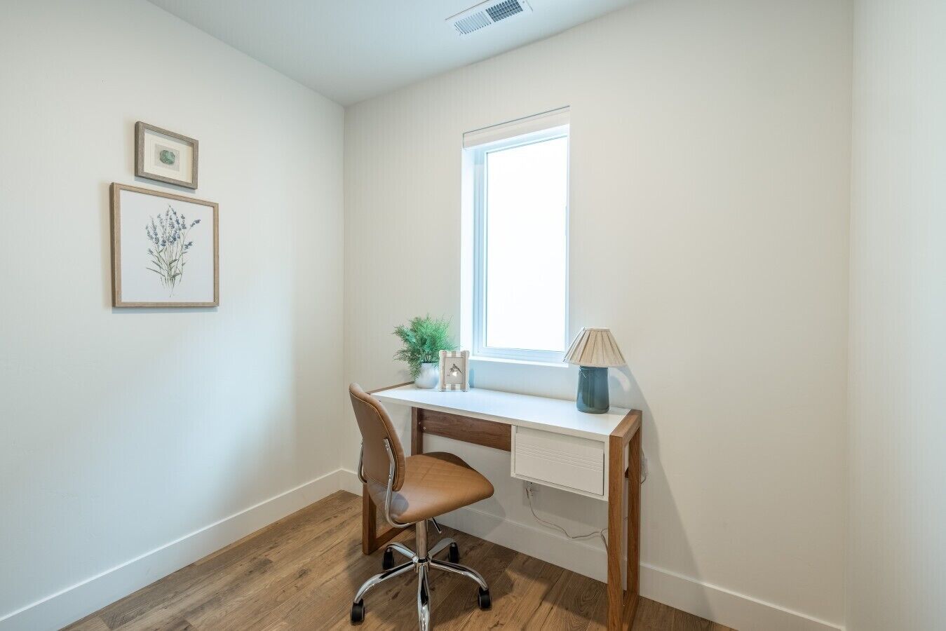 Une pièce avec un bureau, une chaise et une fenêtre.