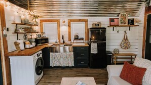 Une cuisine compacte équipée d’un lave-linge, d’un four à micro-ondes et d’un réfrigérateur.