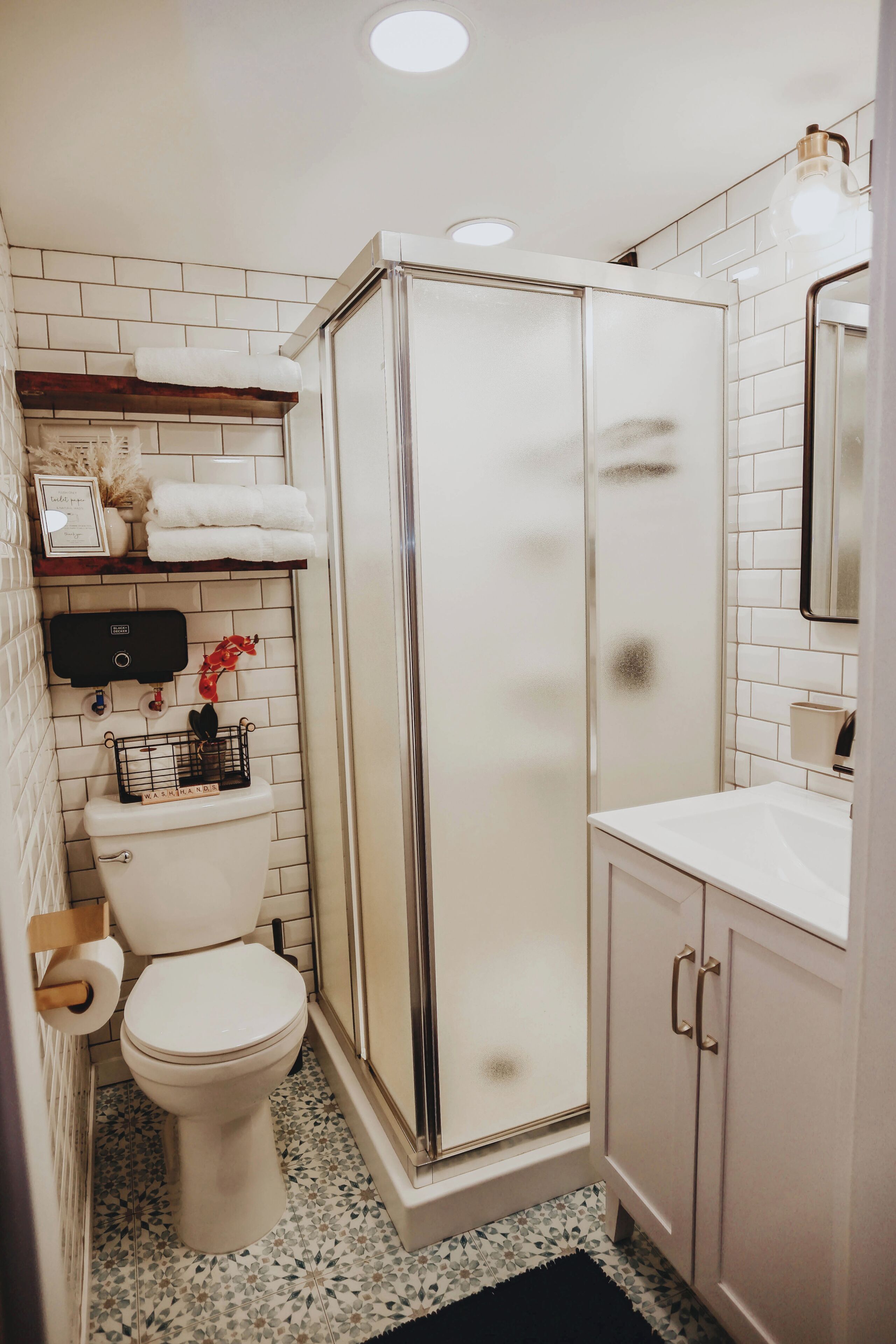 Een badkamer met toilet, douchecabine en wastafel.