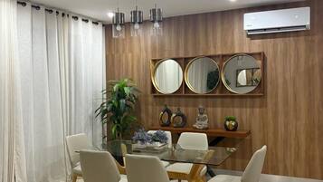 A dining area with a round table, chairs, and a wall-mounted mirror.