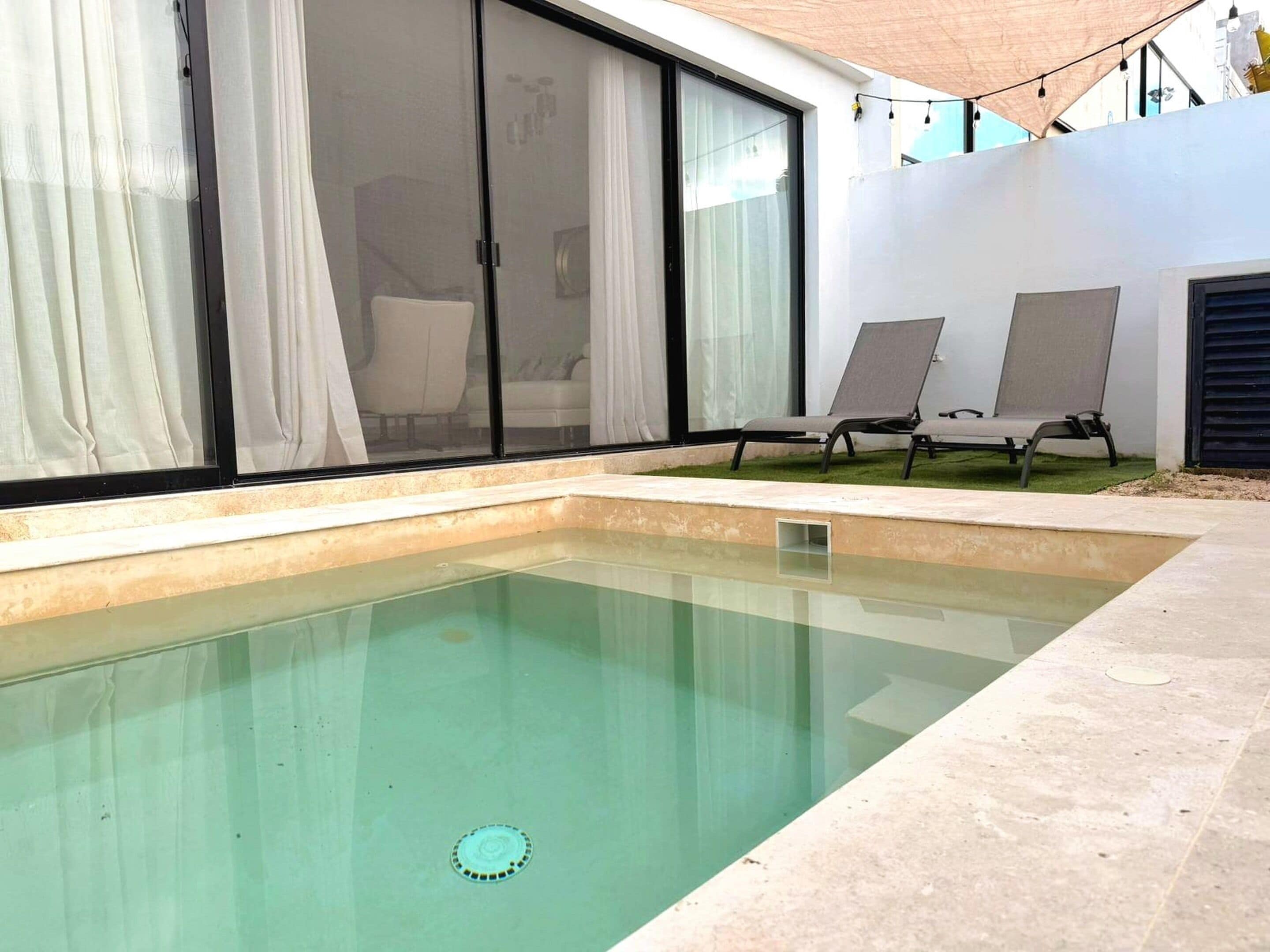 A swimming pool with a clear water drain, surrounded by a tiled deck.