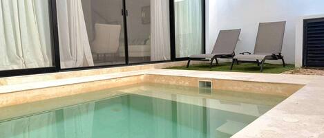 A swimming pool with a clear water drain, surrounded by a tiled deck.