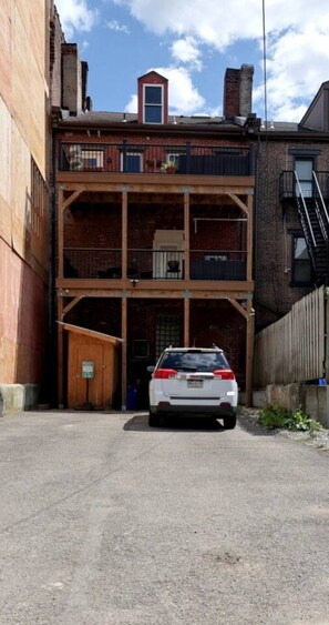 A multi-story building with a car parked in front. - Sunny 2BR | Balcony + Tub | Walk Lawrenceville (Pittsburgh)