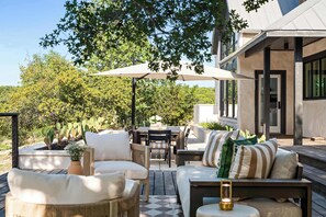 An outdoor patio area with seating, a table, and umbrellas.
