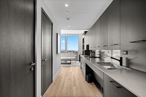 A modern kitchen with dark wood cabinets, stainless steel appliances, and a view to the outside. - Luxury E11EVEN 35th Floor Suite w/ City & Bay View (Miami)