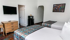 A hotel room with two beds, a TV, a desk, a microwave, and a door. - Family Suite 1 Queen Room (Anaheim)