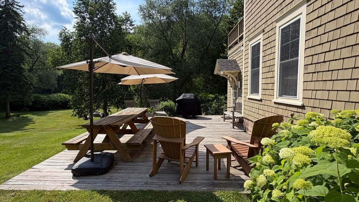 Eine Terrasse mit Picknicktischen, Stühlen und Sonnenschirmen.