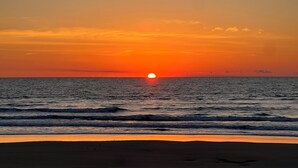 A sunset over the ocean with waves approaching the shore. - Your perfect beach getaway is waiting! 3 bedroom 2 1/2 bathroom beach house. (St. Augustine)