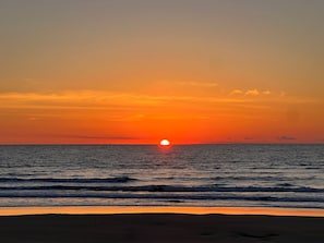 A sunset over the ocean with waves approaching the shore. - Your perfect beach getaway is waiting! 3 bedroom 2 1/2 bathroom beach house. (St. Augustine)