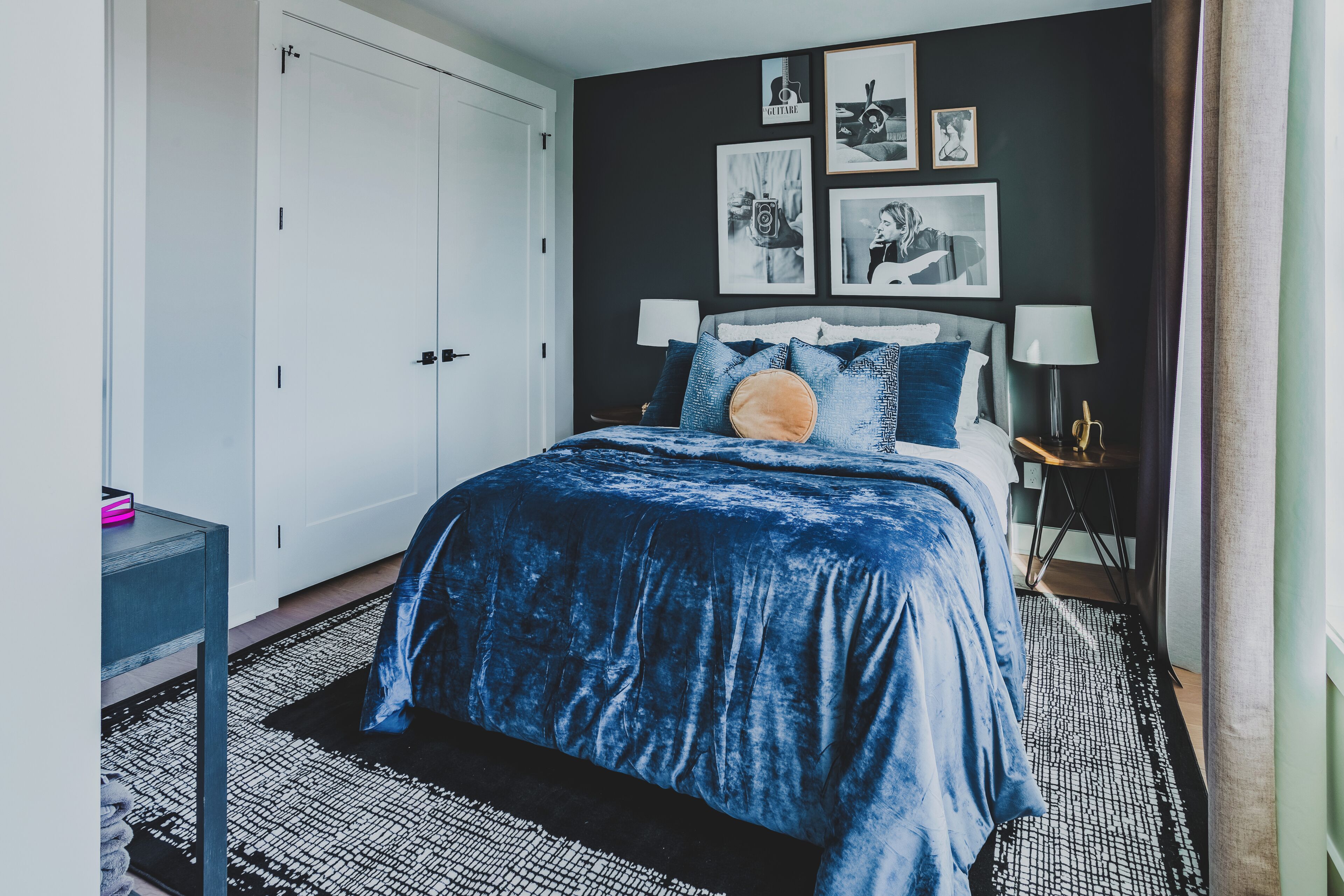 Een slaapkamer met een bed, nachtkastjes, een kledingkast en wanddecoratie.