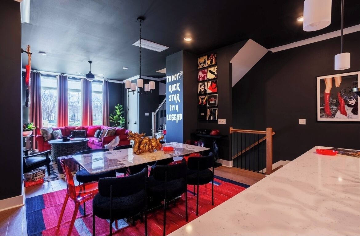 Een modern interieur met een eethoek, een trap en een zithoek met een bank en een salontafel.