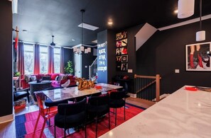 A modern interior with a dining area, a staircase, and a living space with a sofa and a coffee table. - Nashville Legendz: Rooftop Deck (Nashville)