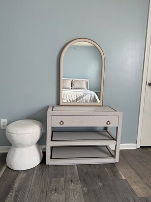A room with a bed, a nightstand with drawers, a round stool, and a mirror. - Lake Access 3 Bedroom Townhome Near Chic's Beach & Airport (Virginia Beach)