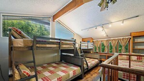 Un dormitorio con literas, un escritorio de madera y una ventana con cortinas.