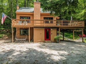 Eine Holzhütte mit rotem Eingang und überdachter Veranda.