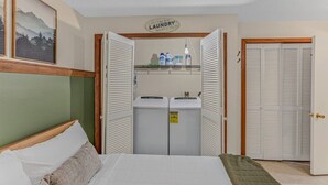 Ein Schlafzimmer mit einem Bett, einer Waschgelegenheit mit einem Schild und einem Schrank mit Klappläden.