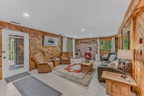 Ein gemütliches Blockhaus-Interieur mit Kamin, Sitzecke und Schild für North Woods Vacation Rentals.