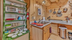 Een keuken met houten kastjes, een roestvrijstalen spoelbak en een aanrecht.
