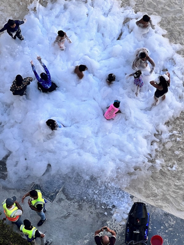 Un groupe de personnes joue dans une grande pile de neige.
