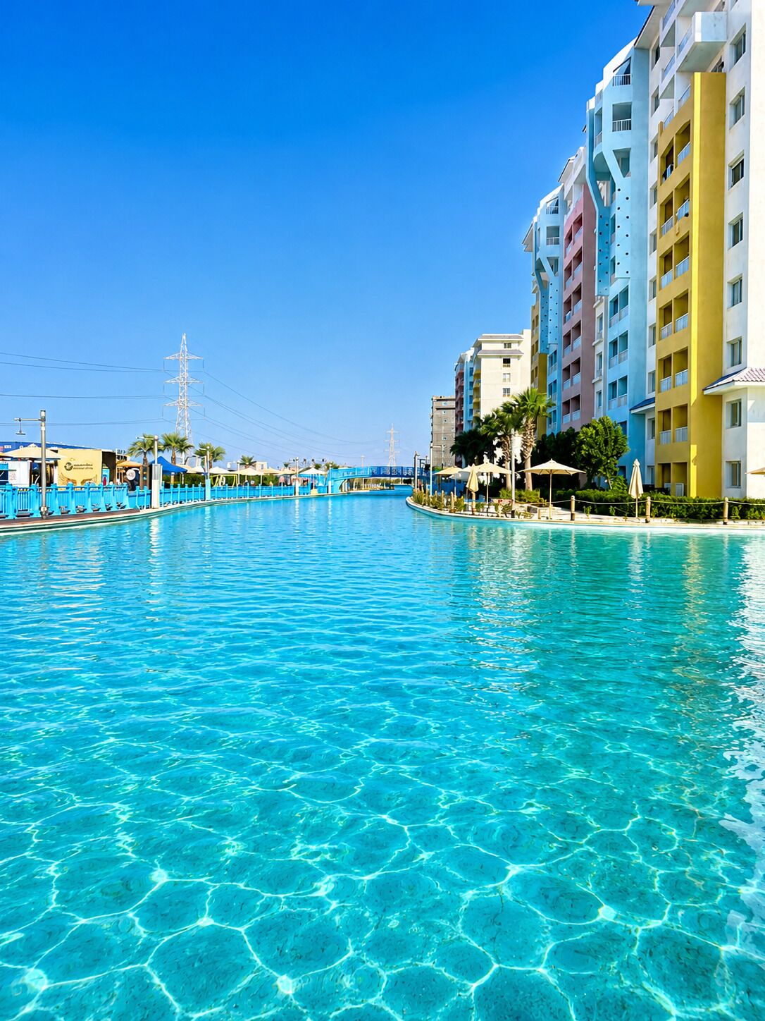 A clear blue pool surrounded by multi-story buildings with balconies.