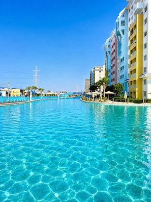 Une piscine d’un bleu éclatant, entourée d’immeubles à plusieurs étages dotés de balcons.