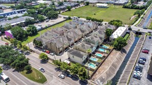 A residential area with multiple houses, a parking lot, and a swimming pool. - Afrotique HOU Getaway Pool!Galleria!Uptown (Houston)