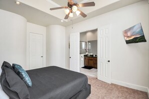 A bedroom with a bed, a ceiling fan, and a view into the kitchen. - Afrotique HOU Getaway Pool!Galleria!Uptown (Houston)