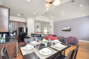 Una cocina moderna con comedor, una sala de estar con sofá y una escalera que conduce a un nivel superior.