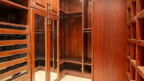 A walk-in closet with wooden shelving and drawers.
