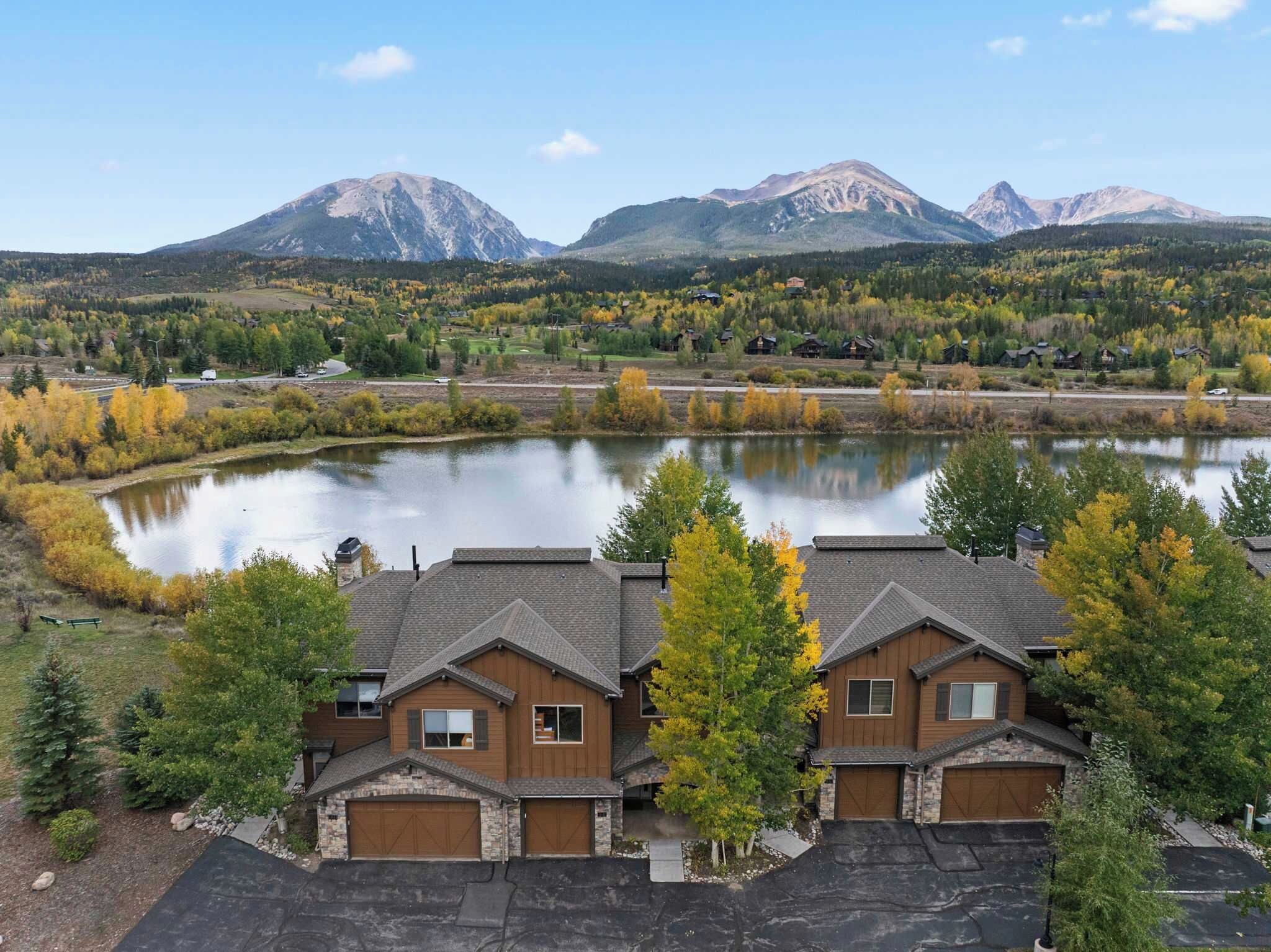 A residential area with houses, a lake, and mountains in the background.
