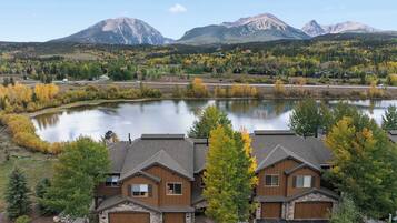 A residential area with houses, a lake, and mountains in the background.