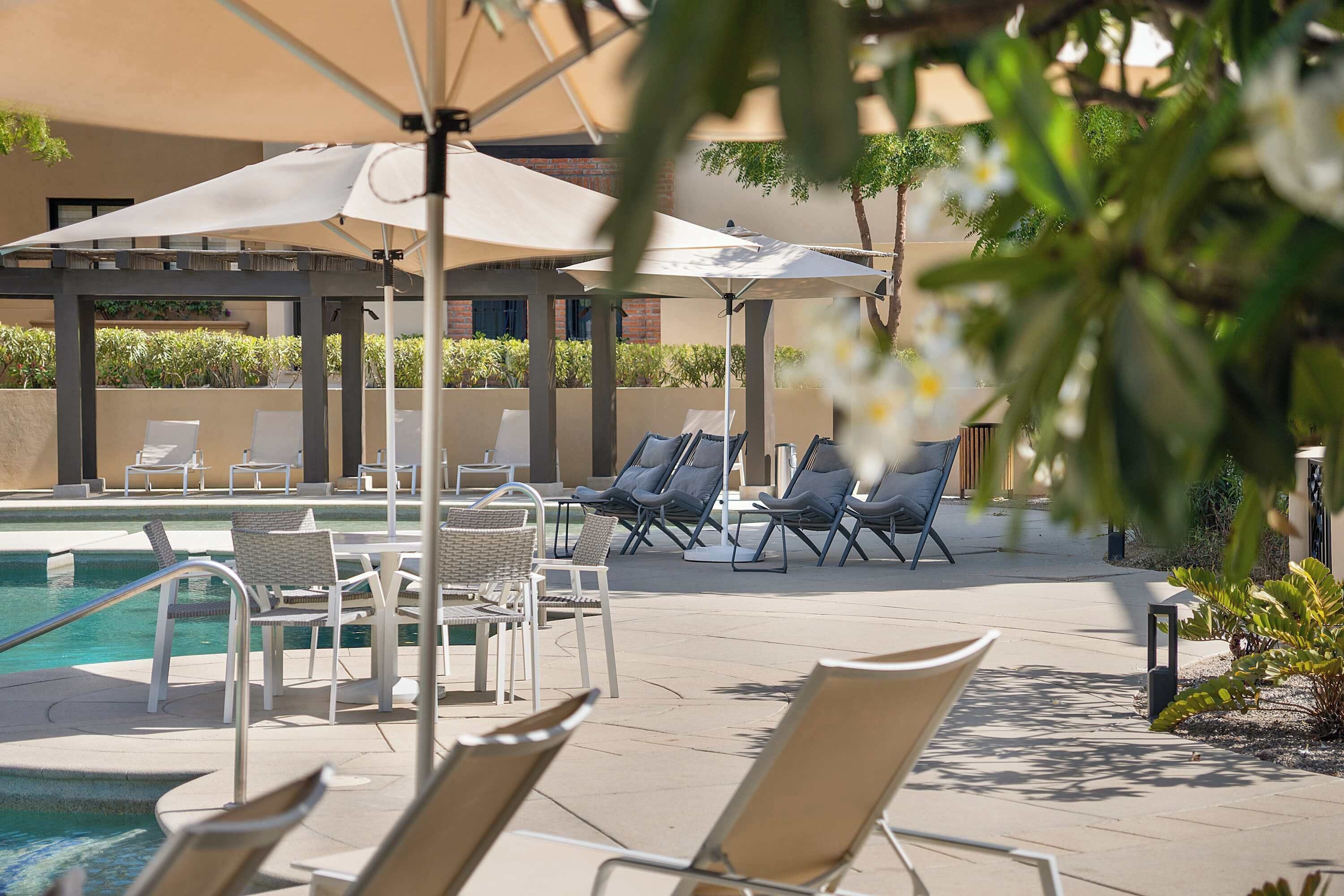 Ein Poolbereich mit Liegestühlen und Sonnenschirmen.