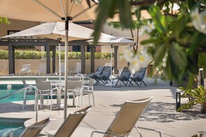 A poolside area with lounge chairs and umbrellas. - Mavila Luxury Condo | Golf, Spa & Quvira Lifestyle (Cabo San Lucas)