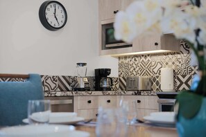 Eine moderne Küche mit einer Uhr, einer Kaffeemaschine und einem Toaster.