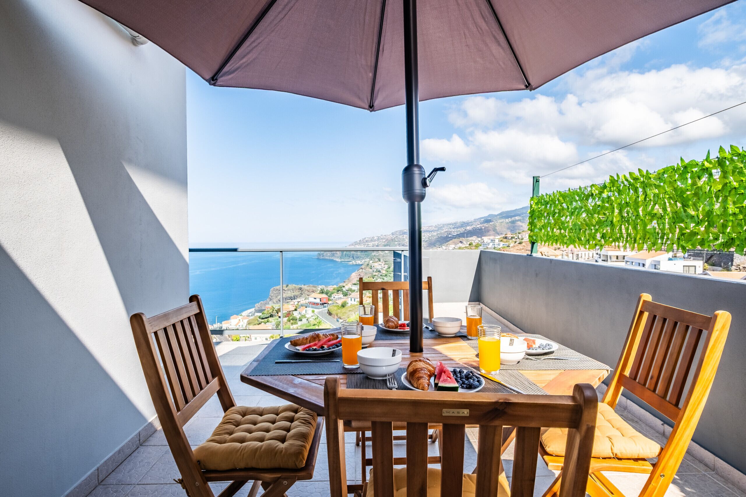 Balcón con una mesa dispuesta para el desayuno, con vista al mar.