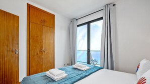 Une chambre d’hôtel avec un lit, une armoire et un balcon offrant une vue.